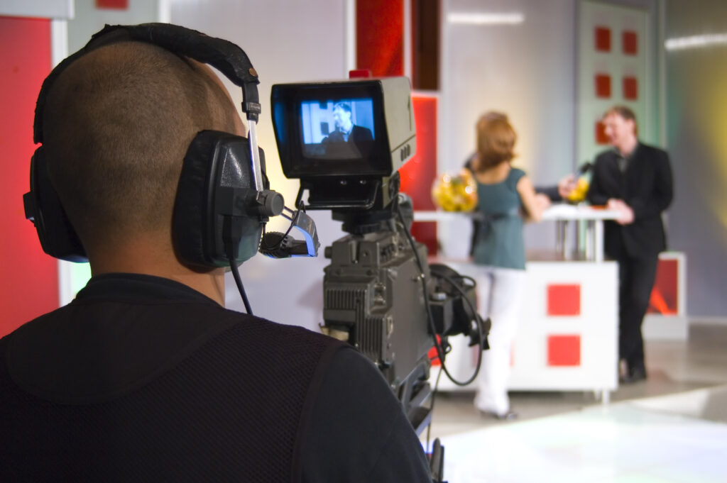 a man wearing headphones is filming a woman